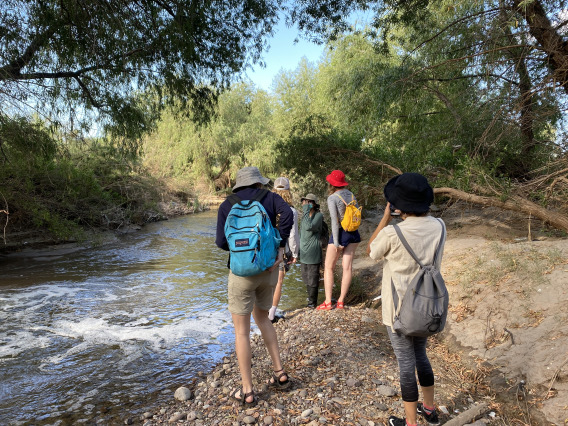 students walking alongside creek