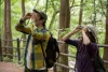 Two citizen scientists use binoculars to observe forest wildlife.